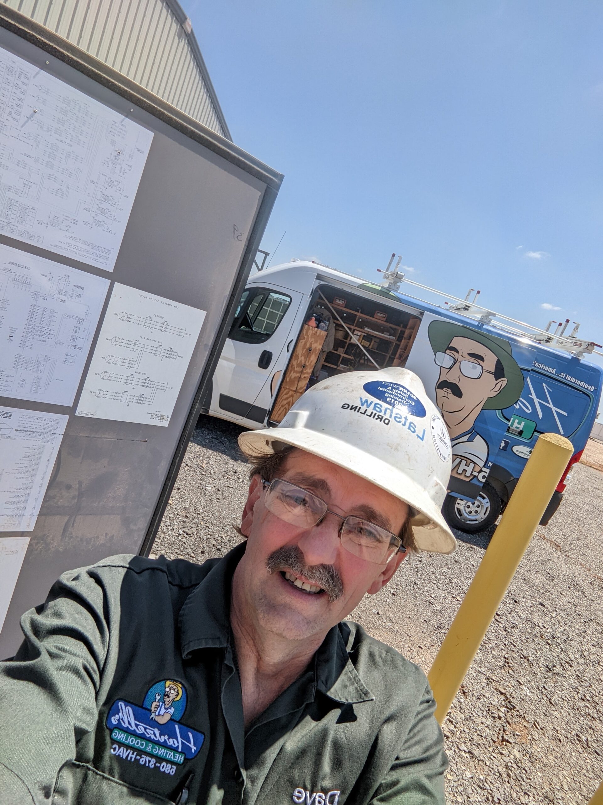 Dave Hartzell reviewing HVAC system at job site — inspecting drain lines and condensate system