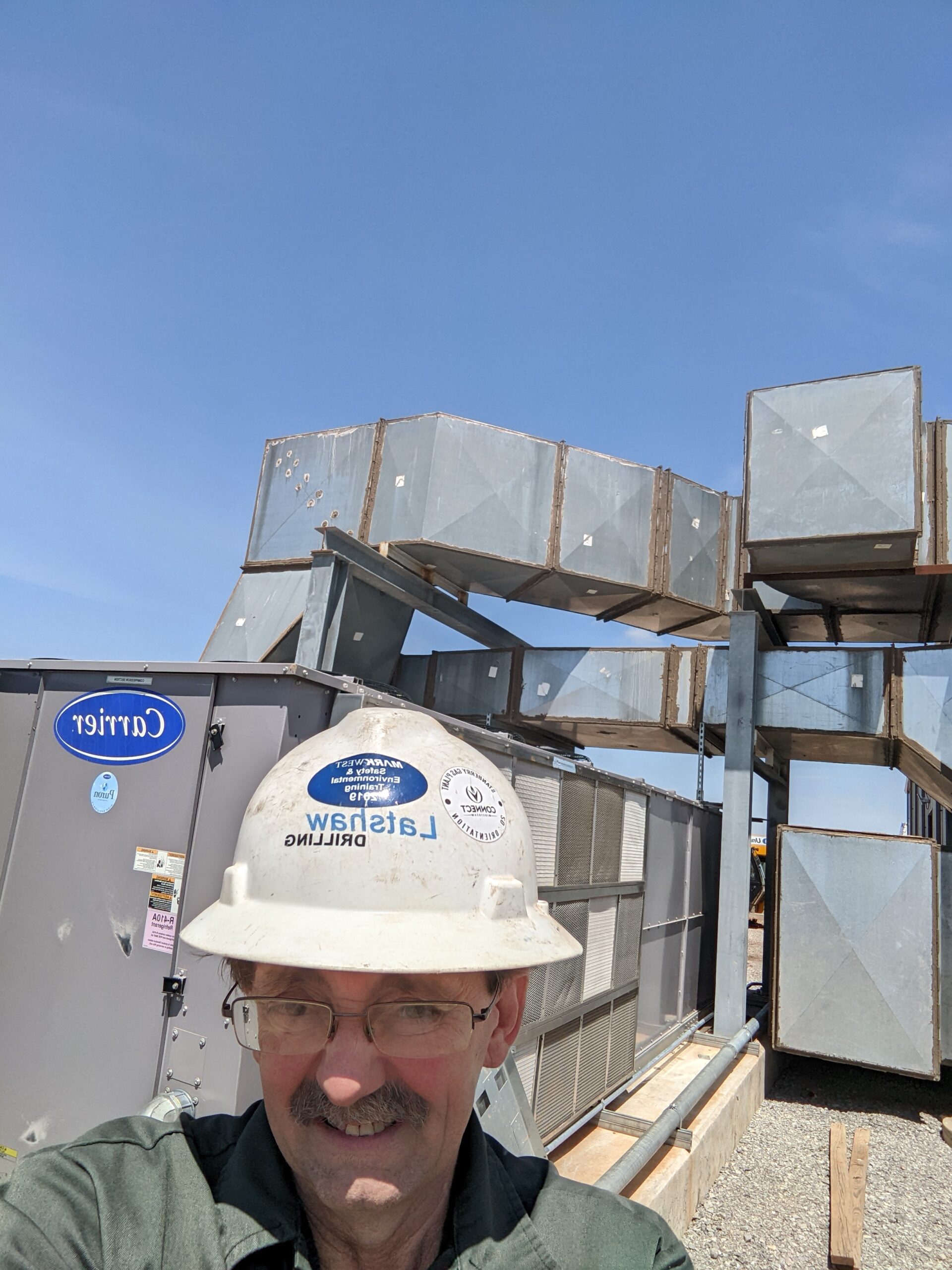 Dave Hartzell with 60-ton Carrier commercial rooftop HVAC units at Oklahoma gas processing plant