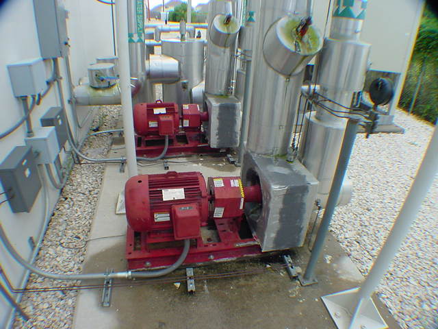 Three red hydronic pump motors on chilled water loop for McQuay chiller at data center