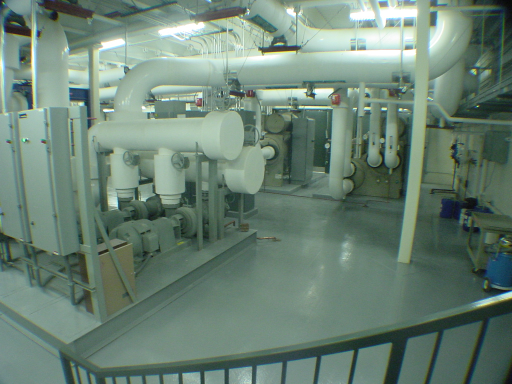 Completed centrifugal chiller plant with white insulated pipe headers and pump skid at Sprint infrastructure facility