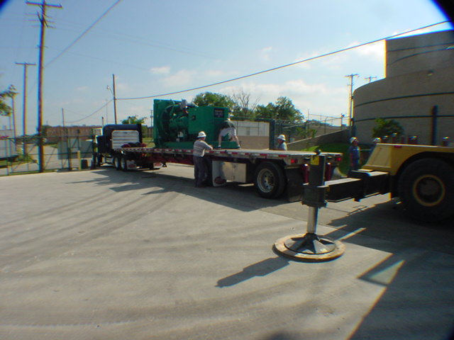 Large Cummins generator set on flatbed truck being delivered to secured data center for installation