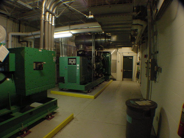 Cummins generator room with containment pads stainless exhaust and clean epoxy floor at commercial data center