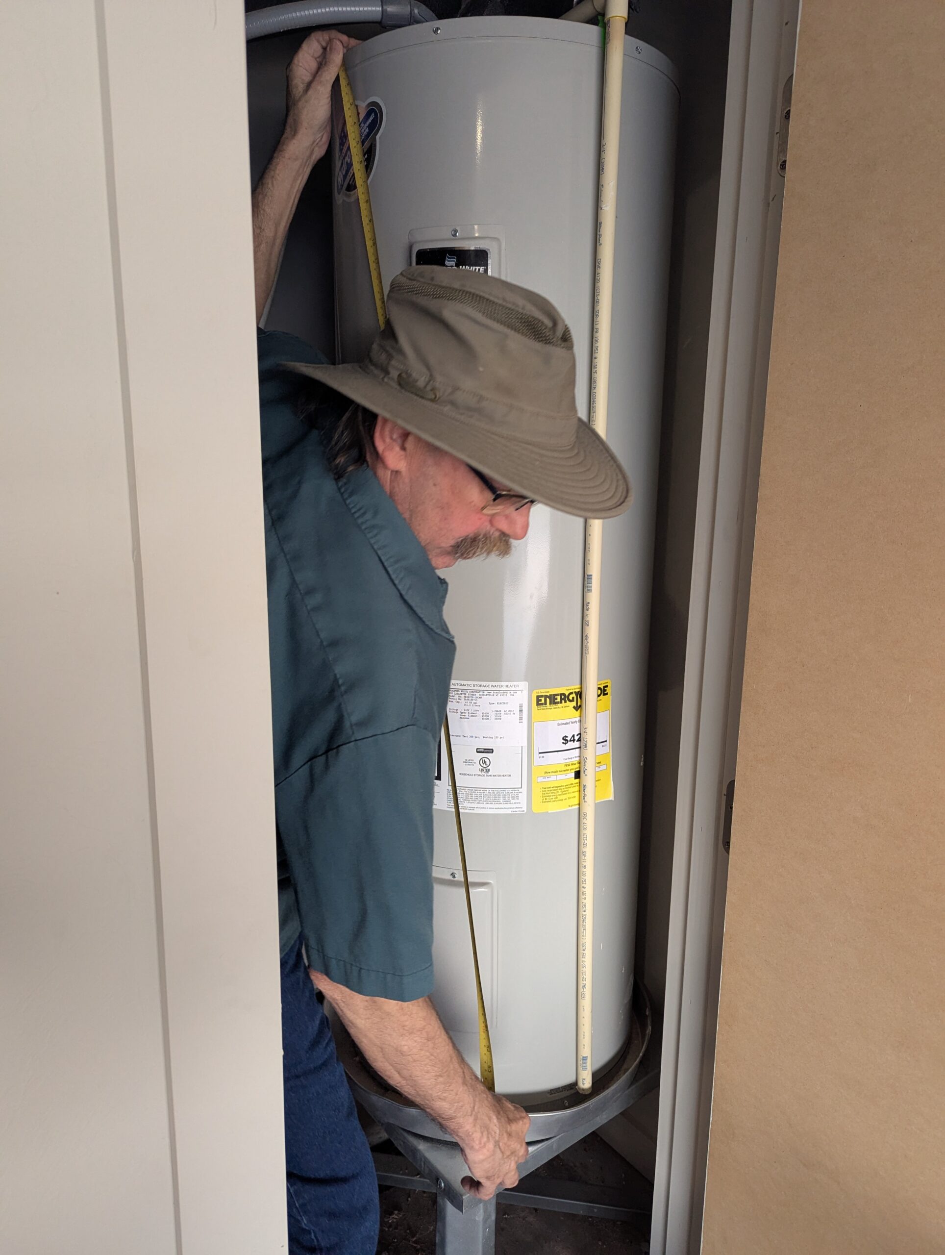 Dave Hartzell measuring Bradford White water heater during installation in Kingfisher Oklahoma