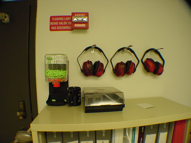 Generator room entry safety station with earmuffs earplug dispenser and Halon 1301 fire suppression warning at critical facility