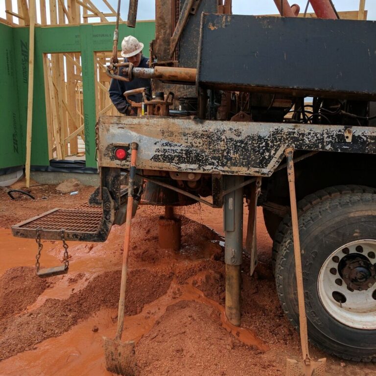 Drill rig boring a geothermal well in Oklahoma red clay
