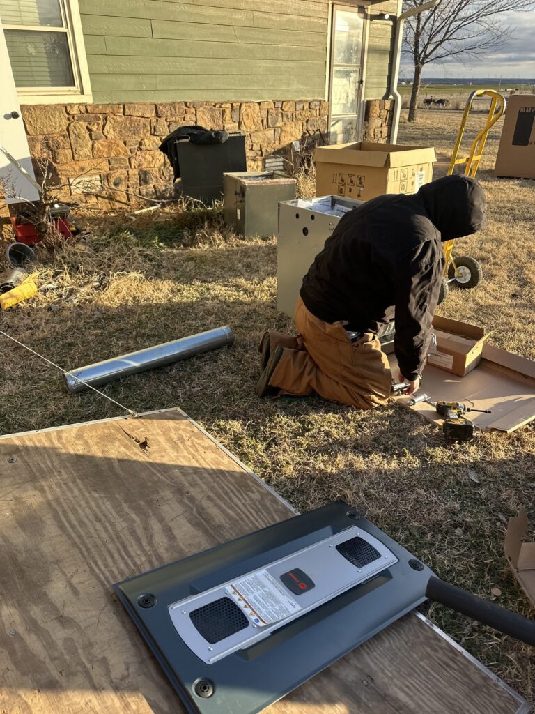Hartzell's Heat & Air technician setting up a new HVAC system at a central Oklahoma home