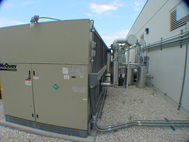 McQuay ALS170 air-cooled water chiller exterior at data center with insulated piping and R-22 hazmat label