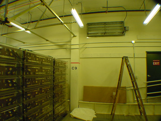 Precision CRAC cooling unit on wall serving telecom battery backup room with raised floor cold air distribution
