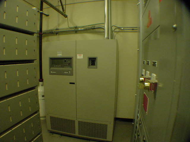 Precision CRAC unit installed between large battery string racks in telecom DC power plant room