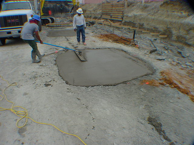 Construction workers finishing fresh concrete pour during Sprint infrastructure foundation work