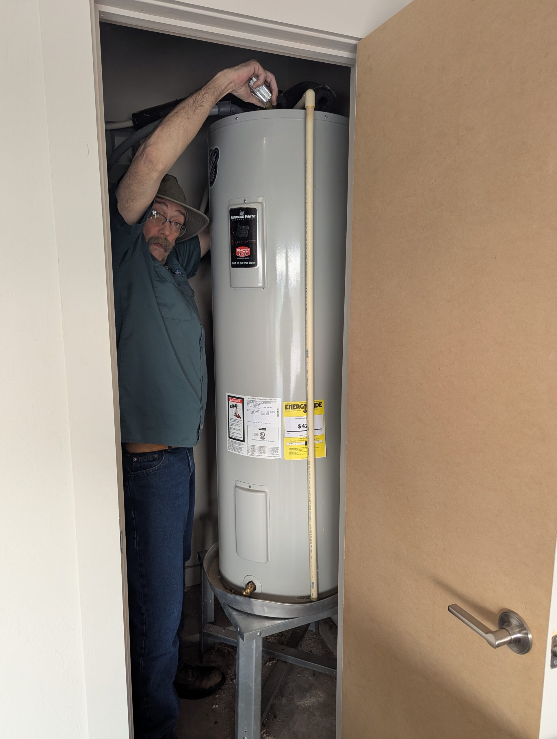 Hartzell's technician installing Bradford White water heater utility room Kingfisher Oklahoma