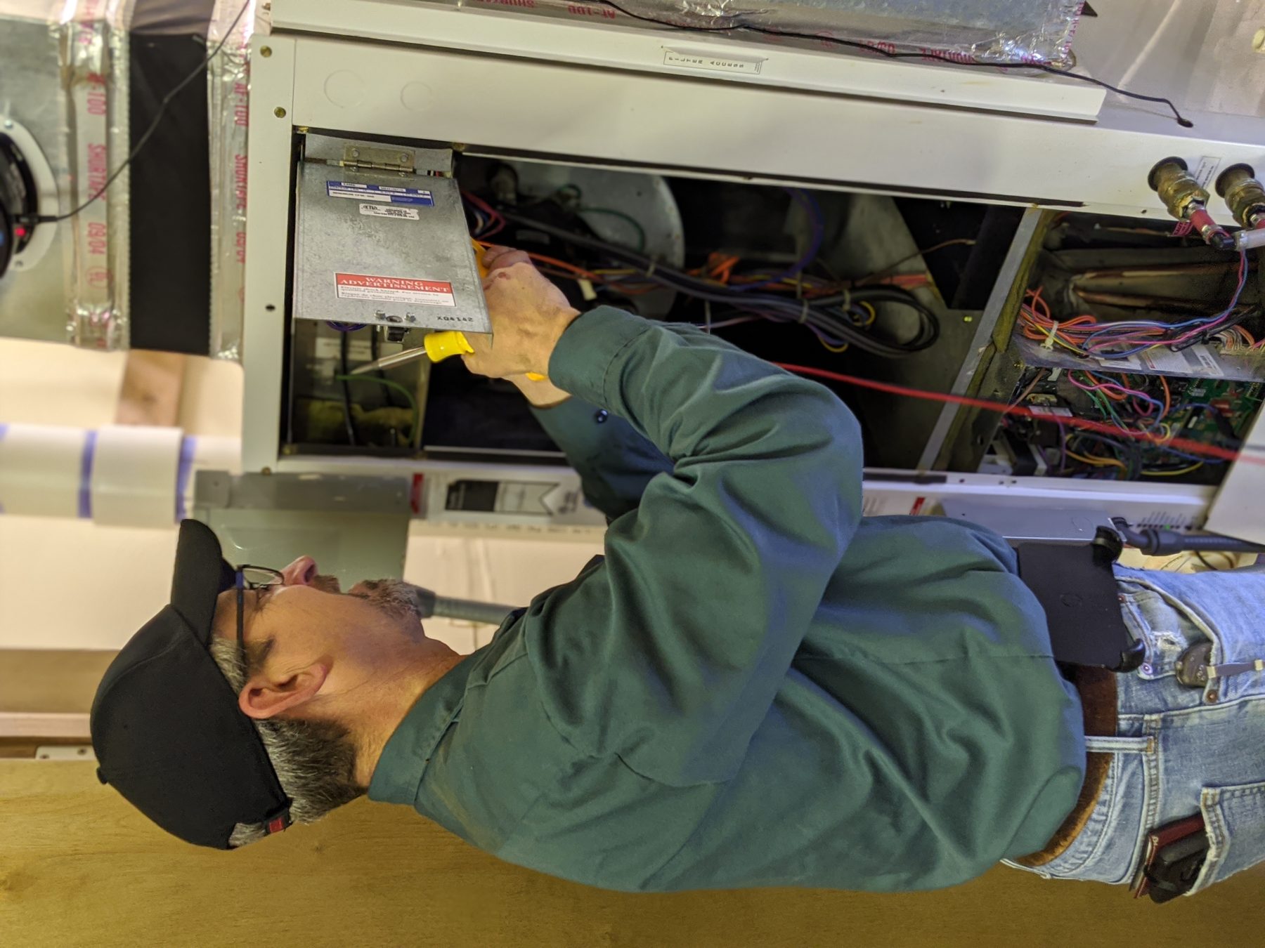 Dave Hartzell servicing a geothermal water-source heat pump air handler at an Edmond, Oklahoma home