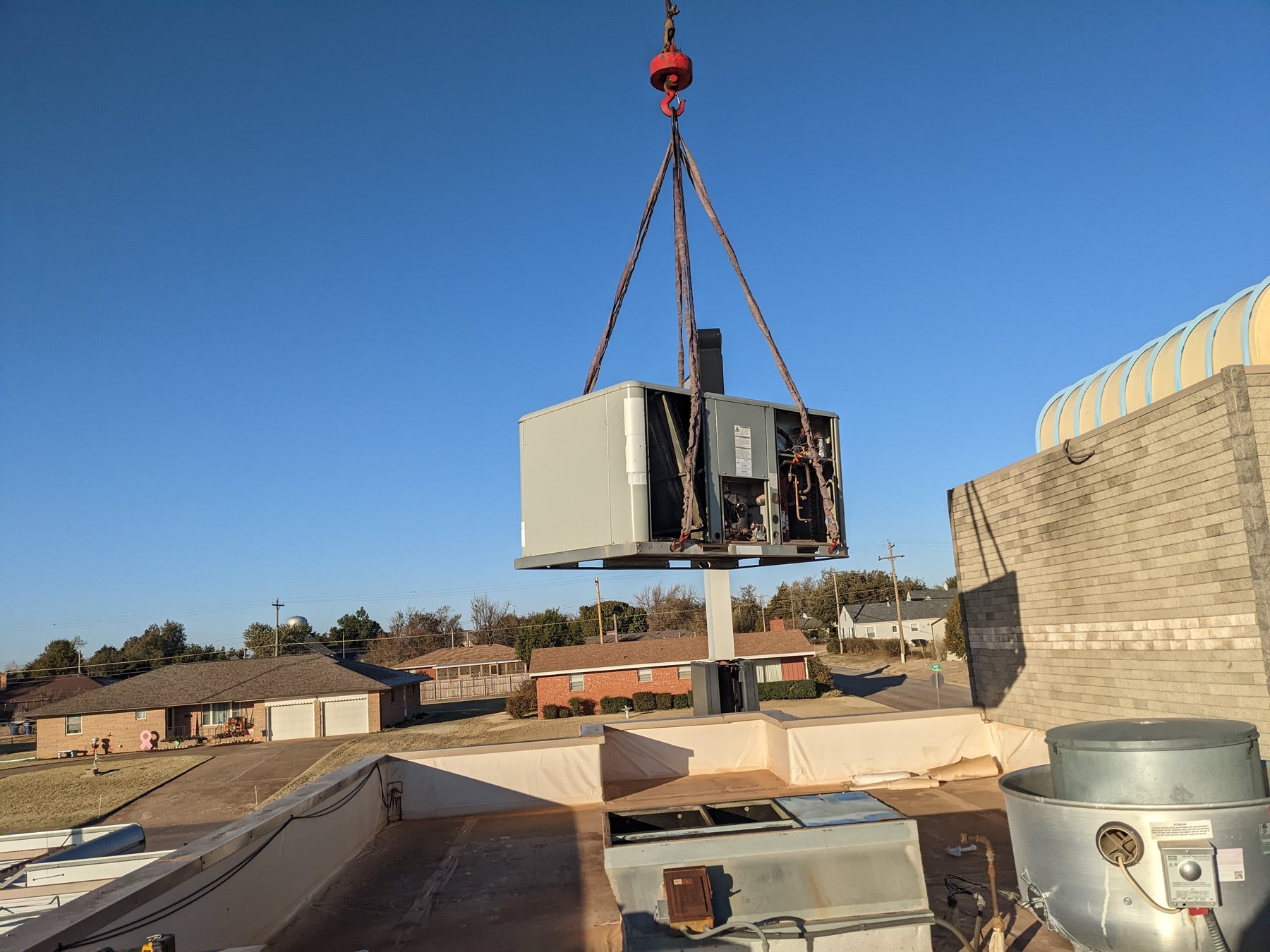 Packaged rooftop air conditioner being craned at the Sonic in Kingfisher, Oklahoma during a commercial HVAC rooftop replacement by Hartzell's Heat and Air