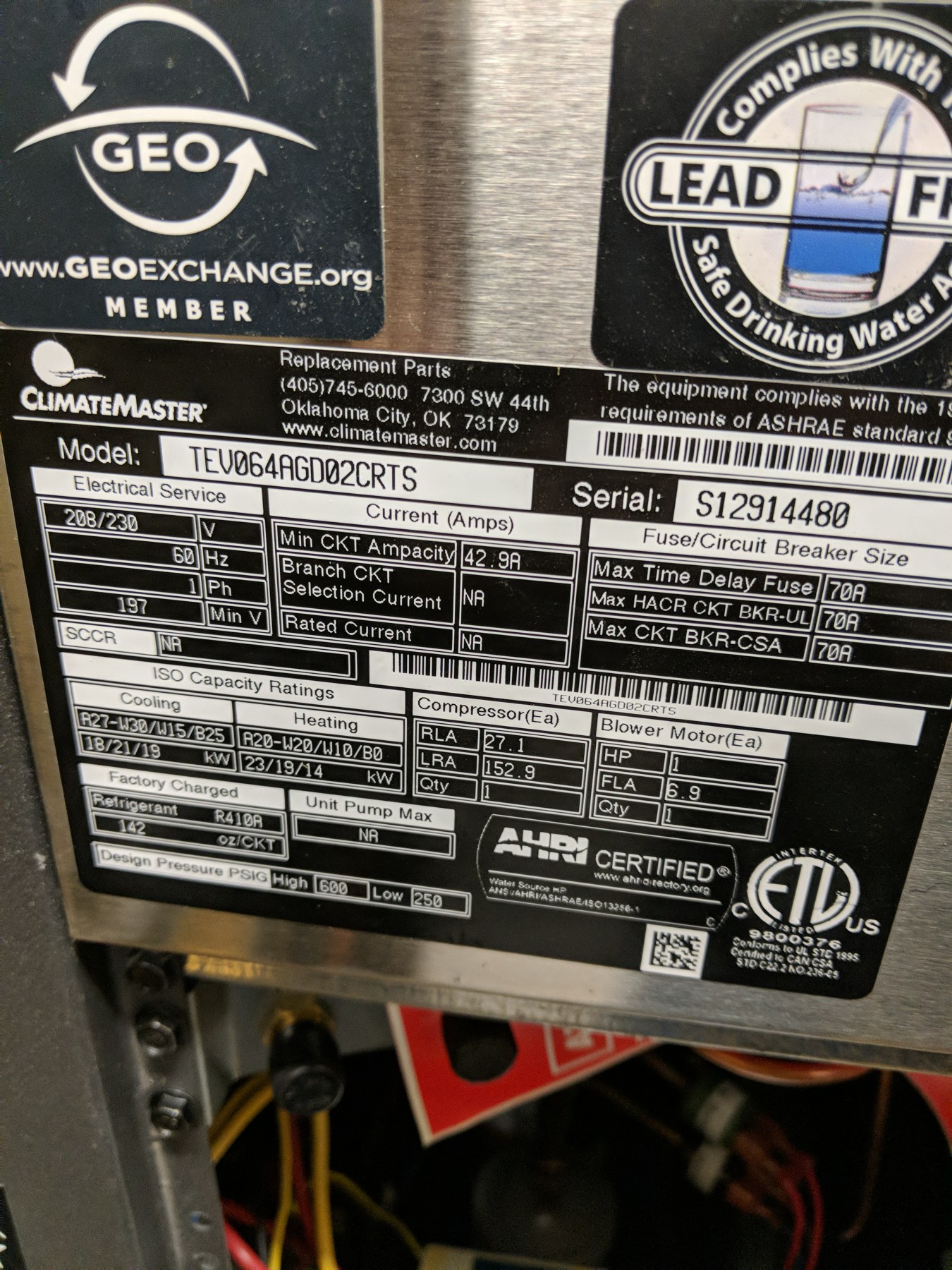 ClimateMaster geothermal heat pump nameplate showing model TEV064AGD02CRTS with the GeoExchange member logo on a water-source unit at the Wheeler Brothers facility in Watonga, Oklahoma