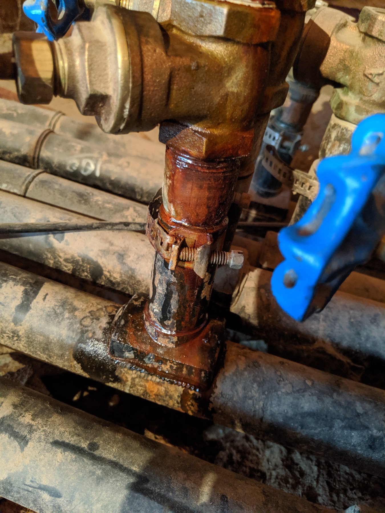 Geothermal ground-loop circulator pump with brass fittings, isolation valves, and loop piping during a commercial geothermal loop repair at the Wheeler Brothers facility in Watonga, Oklahoma, performed by Hartzell's Heat and Air