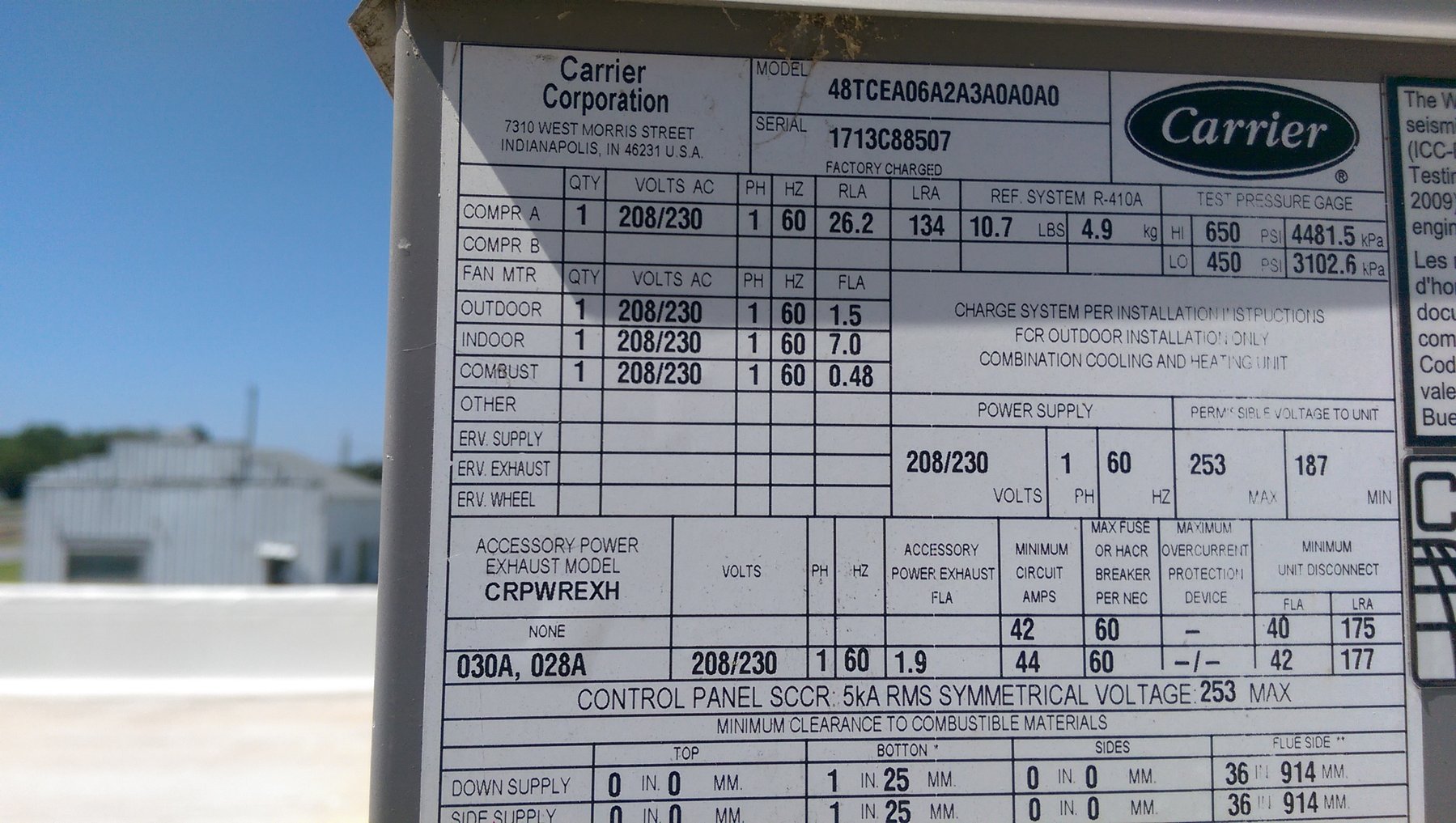 Carrier commercial packaged rooftop unit nameplate showing model 48TCEA06A2A3A0A0A0 on a building at the Wheeler Brothers facility in Watonga, Oklahoma serviced by Hartzell's Heat and Air