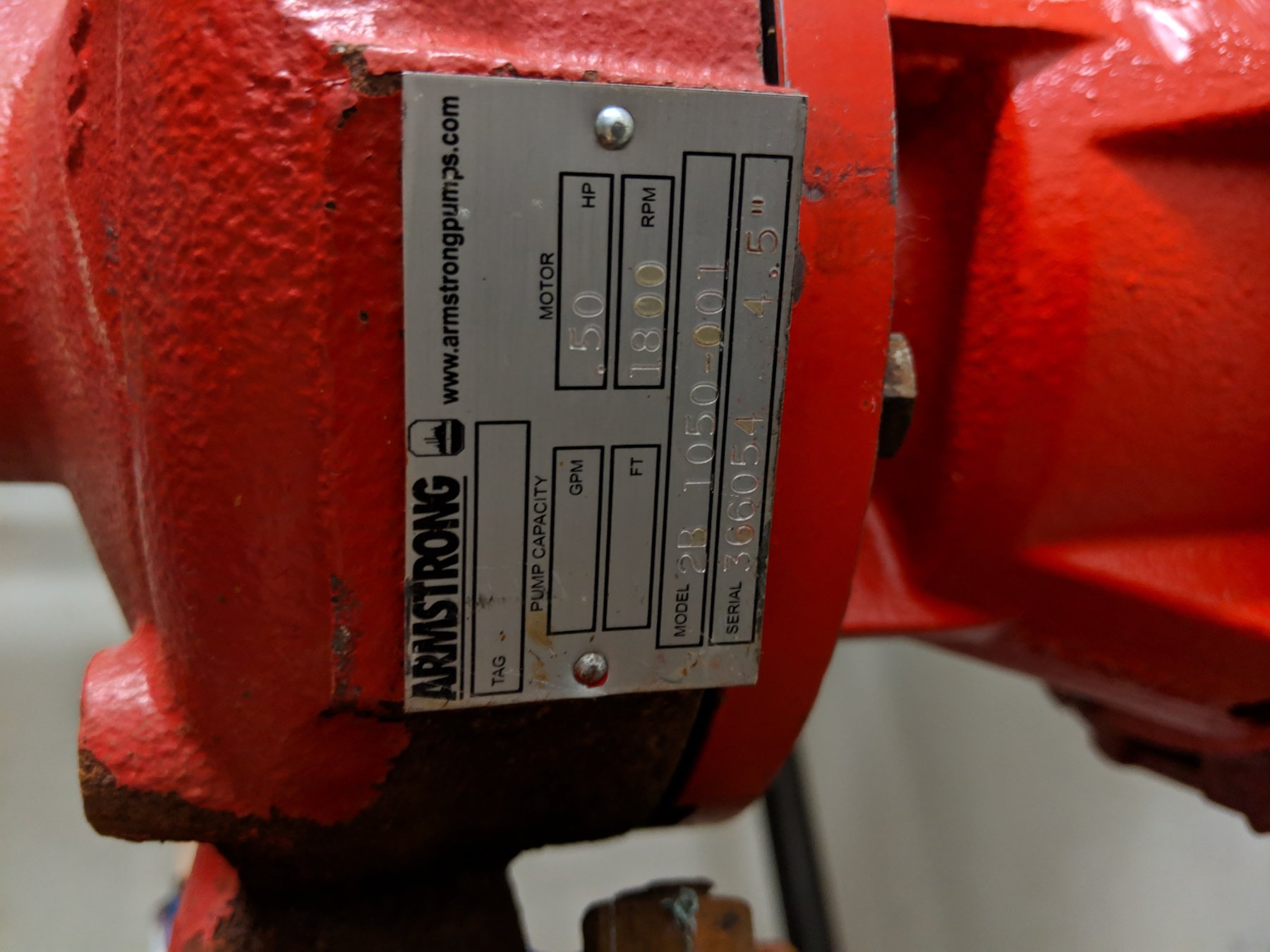 Armstrong commercial circulator pump nameplate in a mechanical room at the Wheeler Brothers facility in Watonga, Oklahoma during a Hartzell's Heat and Air service visit