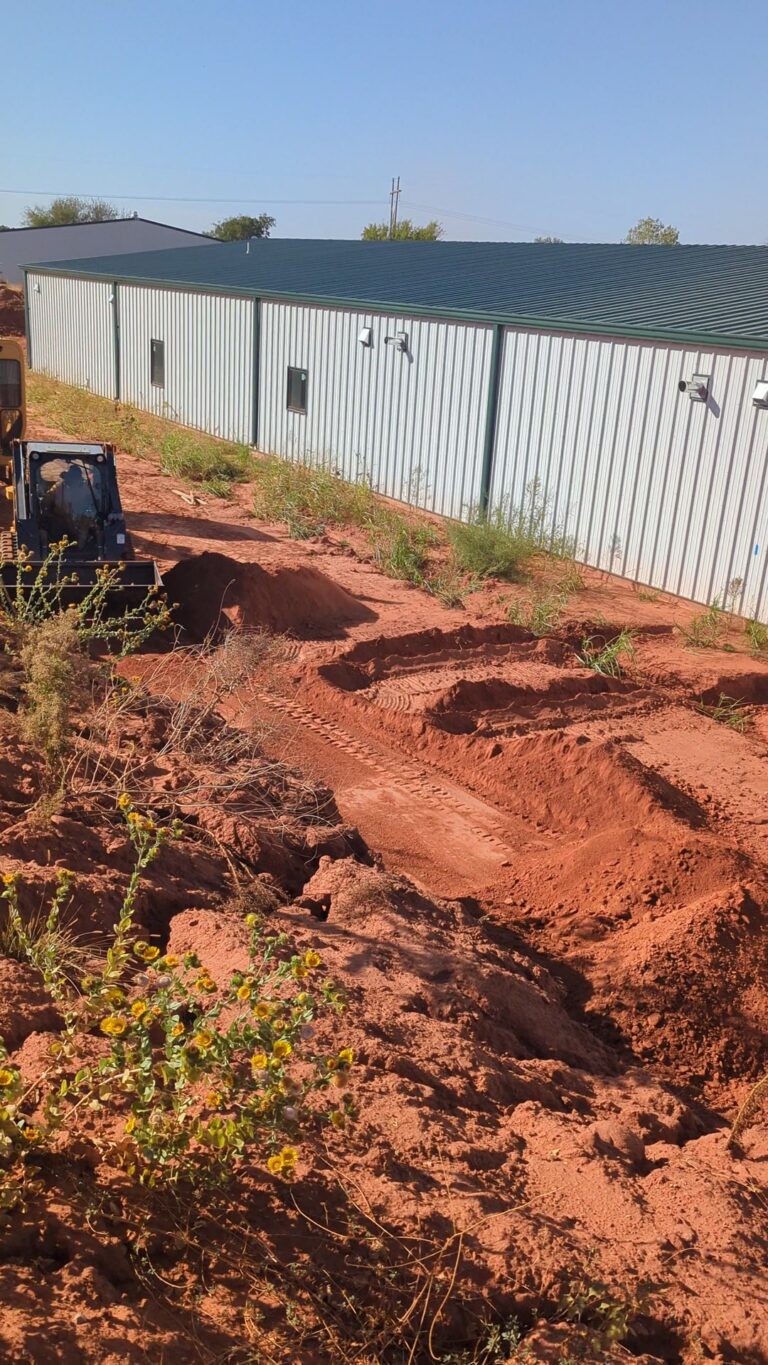 Open geothermal slinky loop trenches in red dirt in Kingfisher County